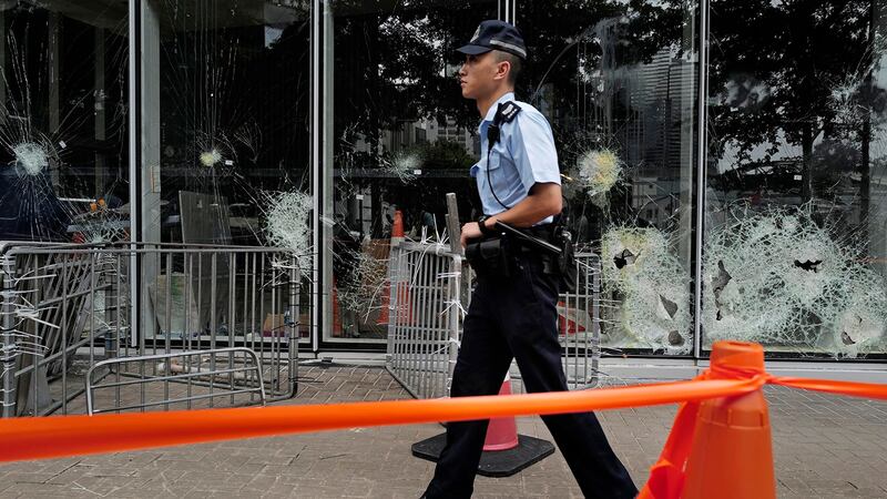 一名香港警察走过被破坏的立法会大楼外面。（美联社）