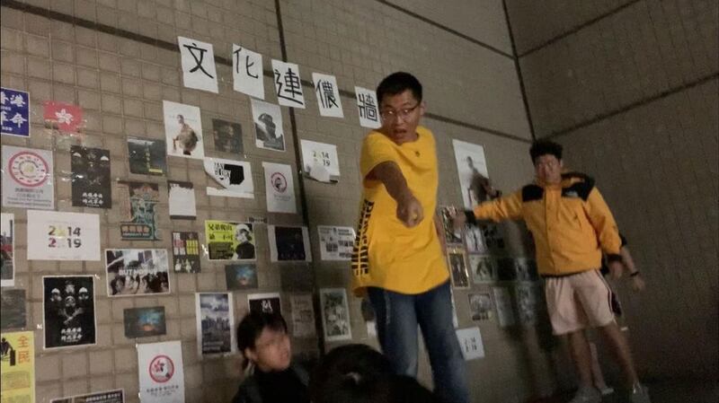 台湾的中国文化大学爆发港生贴连侬墙遭陆生撕毁、施暴。受害港生（下方）被台下女陆生拉下高台。（受害女港生提供）