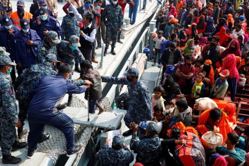 Bangladesh Navy personnel help a disabled Rohingya refugee child to get off from a navy vessel as they arrive at Bhashan Char Island in Bangladesh, Dec. 29, 2020. Credit: Reuters