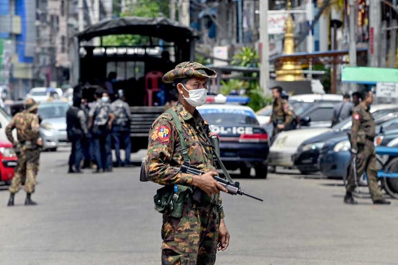 Security forces search for demonstrators as a soldier stands guard along a road in Yangon. (AFP)