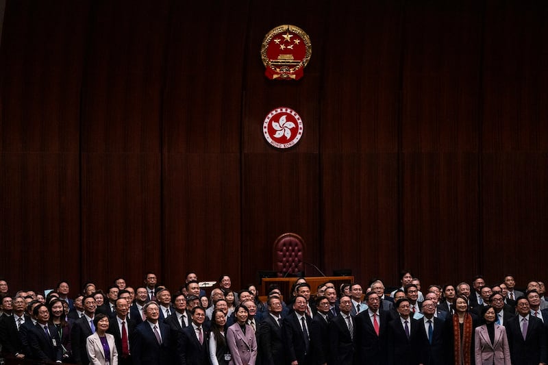 Hong Kong's Chief Executive John Lee, front row, fifth from right, poses for photographs with lawmakers following the passing of the Basic Law Article 23 legislation in Hong Kong, March 19, 2024. (Louise Delmotte/AP)