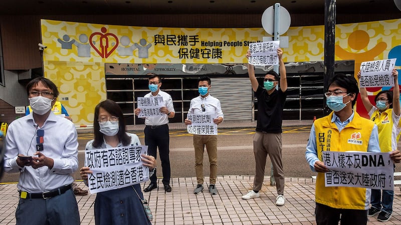 香港民主派政党「新民主同盟」区议员前往香港医管局抗议，反对中国协助在港进行武汉肺炎全民普筛，并痛批特首林郑月娥未先咨询专家与医界，便径自向北京求助，是政治力介入医疗，更担心港人一旦让中方检测人员进行核酸检测，脱氧核醣核酸（ＤＮＡ）资料恐「被送中」。（AFP） 