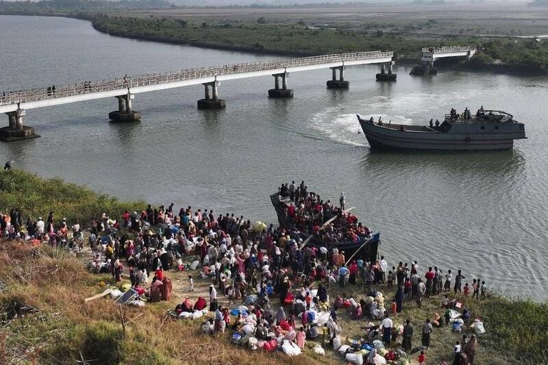 Displaced residents of Myanmar's Maungdaw town board a boat for the journey home in January 2025.