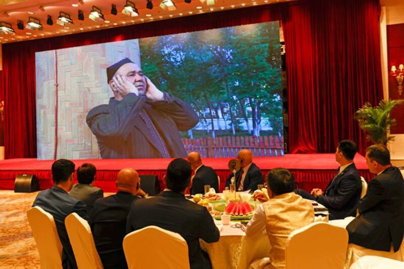 Attendees watch video of a Muslim praying during a government reception held for the Eid al-Fitr holiday in Beijing, China, May 13, 2021. (Ng Han Guan/AP)