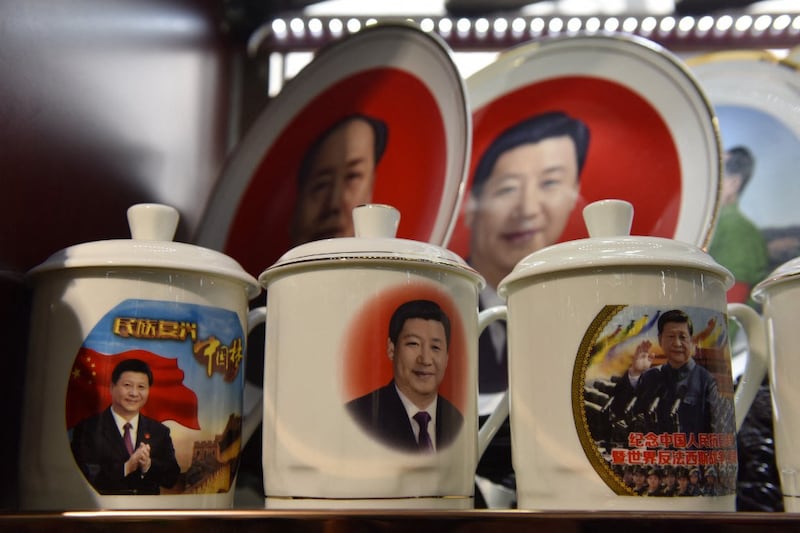 Decorative plates and cups featuring images of Chinese President Xi Jinping are seen in front of a plate featuring late communist leader Mao Zedong (top L) at a souvenir store next to Tiananmen Square in Beijing on Feb. 27, 2018. Credit: AFP