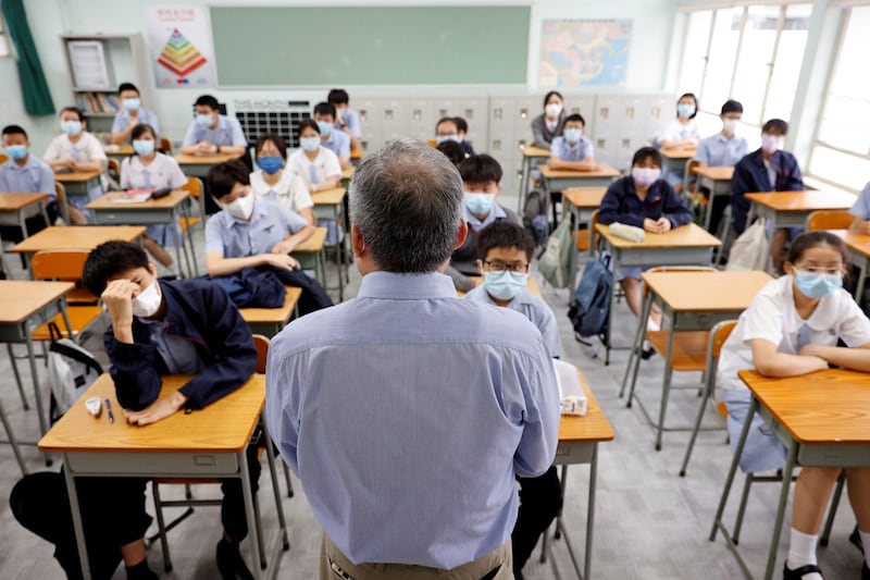 A teacher introduces himself to the students in a classroom at a secondary school during the first day of the new term in Hong Kong, Sept. 1, 2021. Reuters