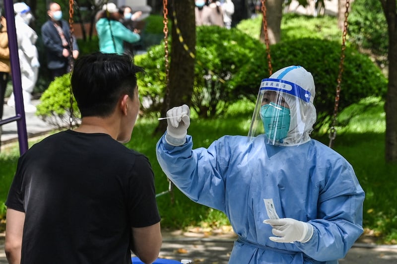 A health worker conducts a swab test for COVID-19 at a residential compound during the second stage of a pandemic lockdown in Shanghai's Jing' an district, April 6, 2022. Credit: AFP