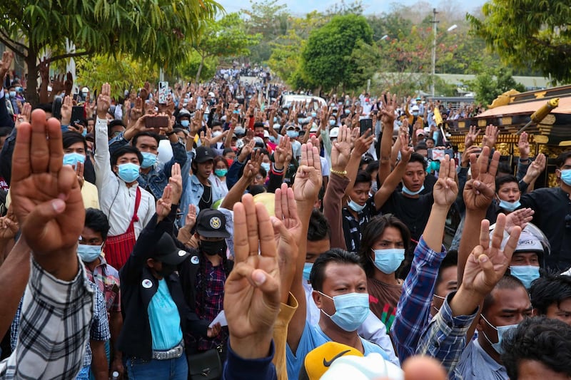 Mourners flash he three-finger protest sign at a rally to honor Mya Thwe Thwe Khine, the first protester to die in demonstrations against the Myanmar military coup, in Naypyidaw, Feb. 21, 2021.