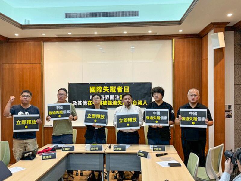 Members of a support group for disappeared Taiwanese publisher Fu Cha hold up signs calling for his release to mark the International Day of the Victims of Enforced Disappearances, Aug. 30, 2024. (Huang Chun-mei/RFA)