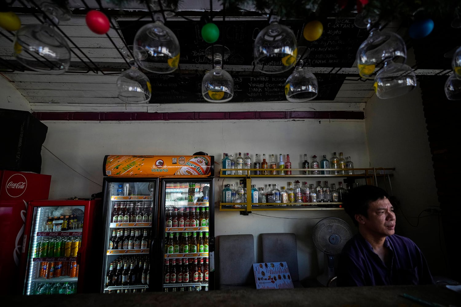 Duong Duc Toan, the manager of Nana Backpacker Hostel sits in the hostel’s bar in Vang Vieng, Laos, Nov. 19, 2024.