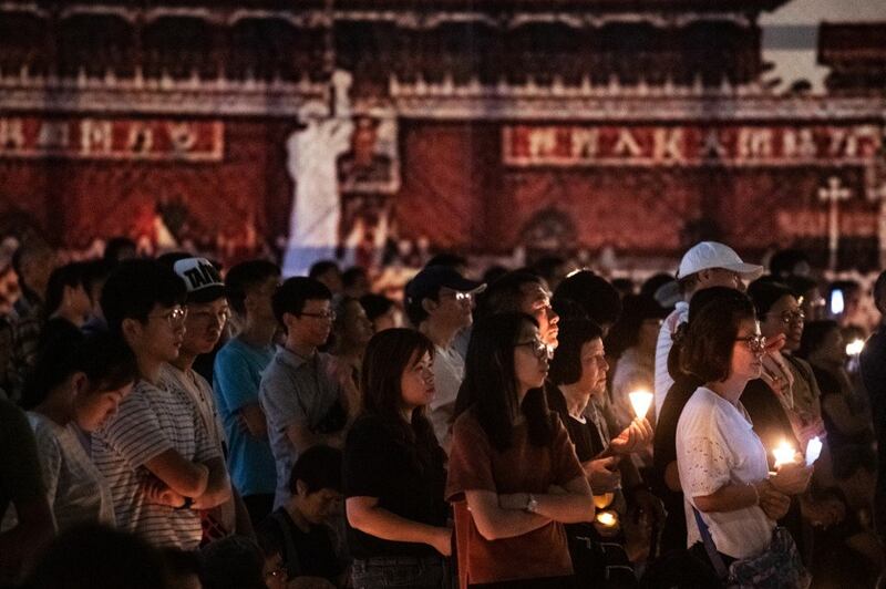 In what turned out to be the final Hong Kong vigil for victims of the 1989 Tiananmen massacre, people attend a candlelight vigil at the city's Victoria Park to mark the 30th anniversary of the 1989 Tiananmen crackdown in Beijing, June 4, 2019. The vigil was banned in 2020 and this year amid coronavirus concerns and a gathering crackdown under a national security imposed by Beijing. Credit: AFP