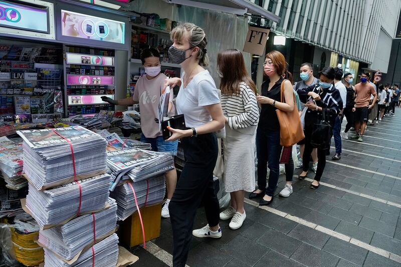 2021 年 6 月 24 日，香港市民在市中心街道的报摊前排队等候最后一期的《苹果日报》。 （美联社）