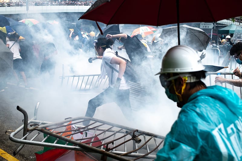 2019年6月12日，香港市民反《逃犯条例》的示威活动中，警察向示威者发射催泪弹。（法新社）