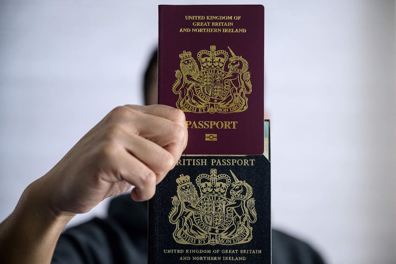 A Hong Kong man poses with his current (top) and old (bottom) British National (Overseas) passports, after a visa scheme offered millions of Hong Kongers a pathway to British citizenship to those wanting to escape China's crackdown on dissent. Credit: AFP