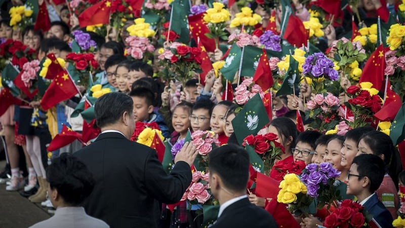 China's President Xi Jinping waves to school students before his departure from the international airport in Macau, which marked 20 years since the former Portuguese colony was returned to China, Dec. 20, 2019. 