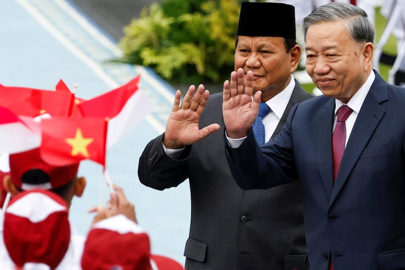 Indonesian President Prabowo Subianto and Vietnam's Communist Party General Secretary To Lam wave to students, as they inspect the guard of honour, during a welcoming ceremony, on the day of their meeting, at the Merdeka Palace in Jakarta, Indonesia, March 10, 2025. REUTERS/Ajeng Dinar Ulfiana