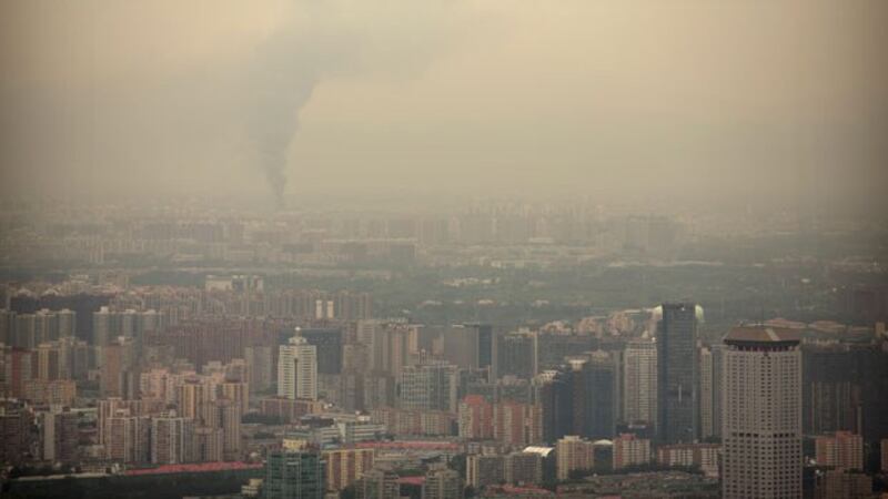 Smoke rises above the skyline of Beijing on a moderately polluted day, Aug. 26, 2017.