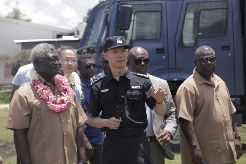 Solomon Islands Prime Minister Manasseh Sogavare looks on as a member of China’s police liaison team talks at the handover ceremony for vehicles that China donated to Solomon Islands police force, on Nov. 4, 2022 in Honiara, the Solomon Islands capital. Credit:Gina Maka’a