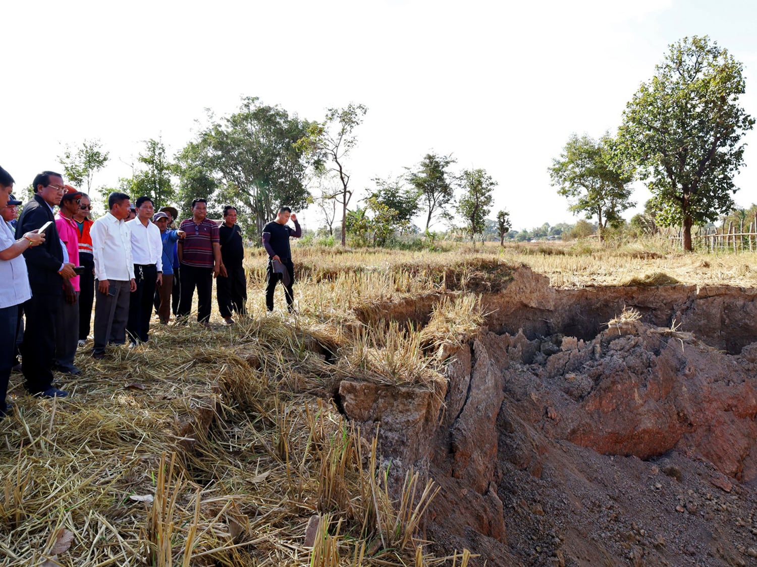 Der Gouverneur der Provinz Khammouane, Vanxay Phongsavanh, links und seine Delegation inspizieren ein Dolkloch im Dorf Pakpeng, Laos, 4. Dezember 2024.