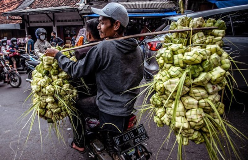 A man sells rice cakes, a common dish to celebrate Eid al-Fitr, which marks the end of the holy fasting month of Ramadan, at a traditional market in Bogor, Indonesia, April 30, 2022. Credit: Aditya Aji/AFP