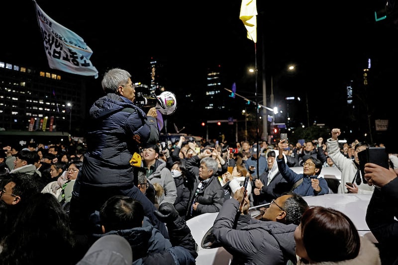 People gesture outside the National Assembly, after South Korean President Yoon Suk Yeol declared martial law, in Seoul, South Korea, 2024.