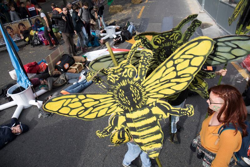 Protesters hold signs depicting bees during a demonstration called by climate change activist group Extinction Rebellion, on at the Place du Chatelet, Paris, October 7, 2019. Credit: AFP