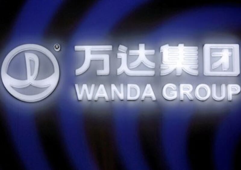 A Dalian Wanda Group sign glows during an event announcing a strategic partnership between Wanda Group and FIFA in Beijing, China, March 21, 2016.