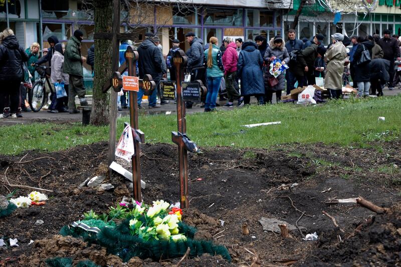 民众在两个俄罗斯攻击乌克兰过程中死去的两个乌克兰人的坟墓前放的鲜花。（美联社）