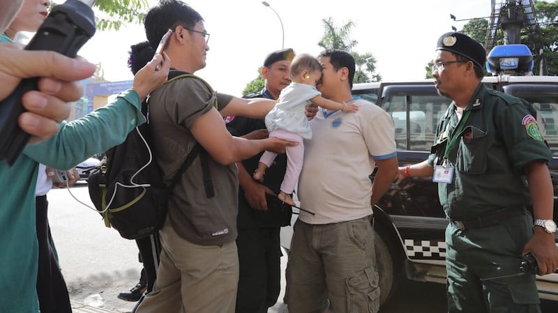 Cambodian activist Kong Raiya kisses his daughter as he is led to court for questioning in Phnom Penh, July 11, 2019.