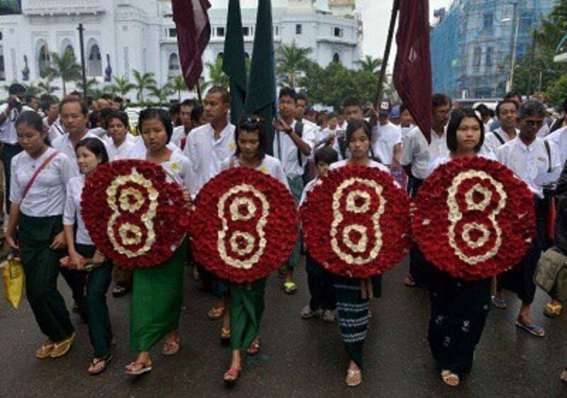 Students carrying wreaths marked with the number eight march in Yangon on Aug. 8, 2013 to mark the anniversary of the 1988 crackdown. Photo credit: AFP. 