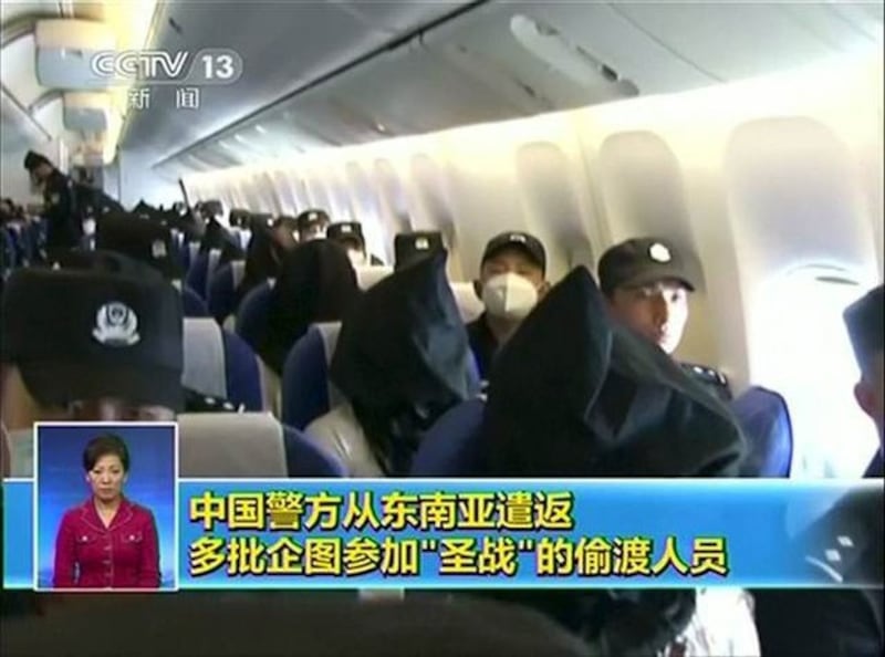 Uyghurs are in custody as they are transport via airplane from Thailand to China, July 9, 2015.