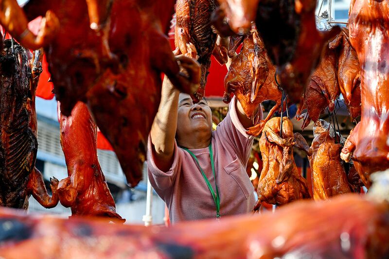 A vendor hangs a roasted pig for sale at a market in Phnom Penh on Jan. 28, 2025.