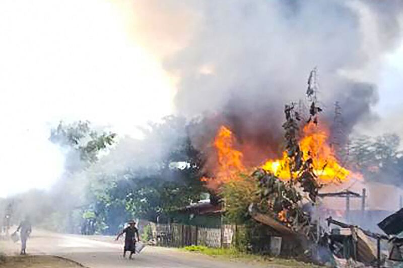 This handout received courtesy of an anonymous source on Sept. 18, 2021 shows people attempting to extinguish a fire as houses burn in Magway division, Sept. 10, 2021. AFP