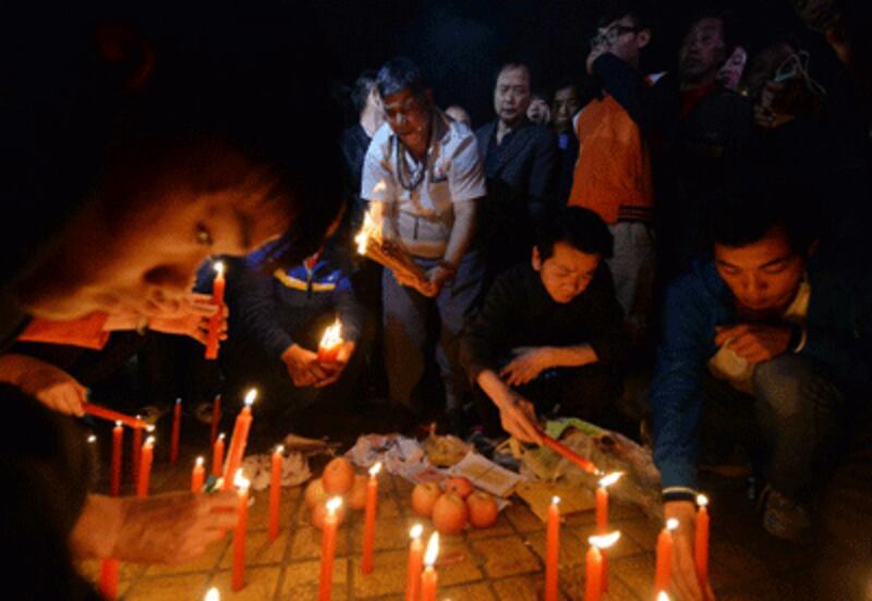 Chinese mourners light candles at the scene of the attack at the main train station in Kunming, Yunnan Province, March 2, 2014.