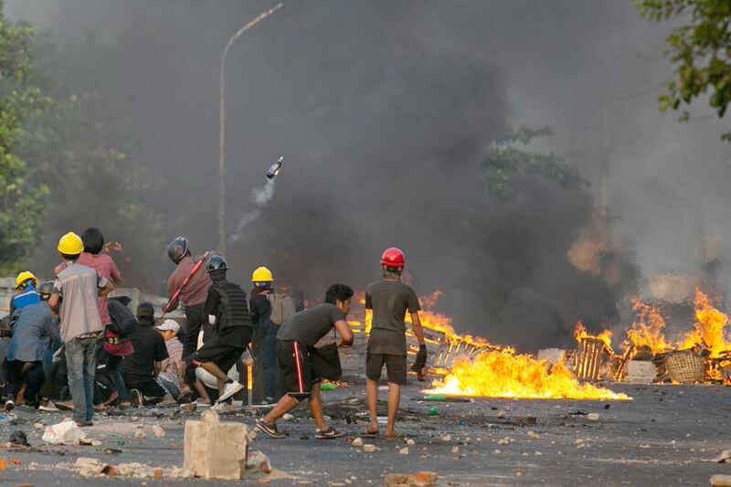 A protester hurls a Molotov cocktail during a confrontation with police Tuesday in Yangon. AFP photo