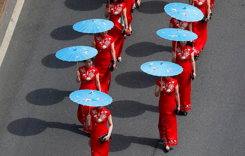 A group of Chinese girls marches in downtown Milan, Italy, May 20, 2017, to support migrants' rights.