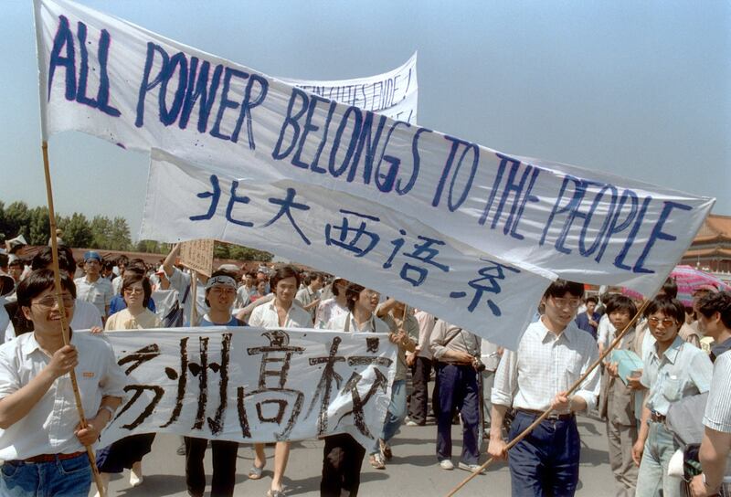 1989年5月25日，北京天安门广场附近，高中生挥舞旗帜游行，支持民主抗议。（法新社）