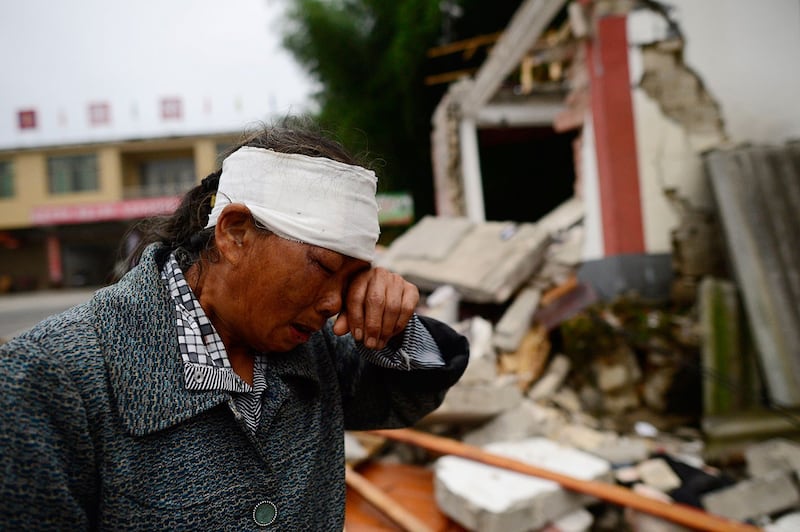 2019年6月17日，四川宜宾长宁县深夜发生6级地震，造成房屋倒塌，逾两百人伤亡。图为18日地震后，一名受伤的妇女在受地震破坏的建筑物附近。（法新社）