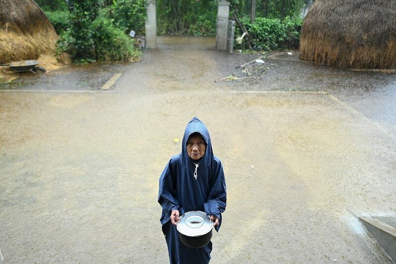 Hình minh hoạ. Một phụ nữ lớn tuổi cầm bát cơm cạnh căn nhà ngập nước của bà ở Hải Lăng, tỉnh Quảng Trị hôm 16/10/2020 