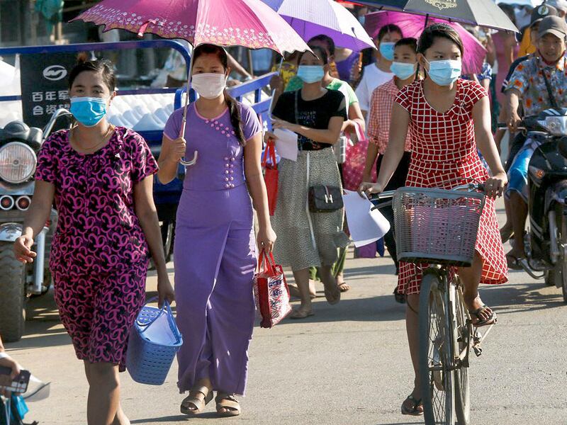 Woman make their way on a street in Hlaing Tharyar Township, Yangon, Myanmar, May 16, 2020.