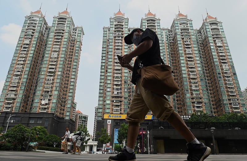 一名男子走过广州市恒大的住宅区。 （法新社)