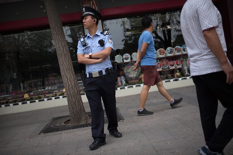 一名警察在北京天安门广场附近街道的人行道上站岗。 （美联社）