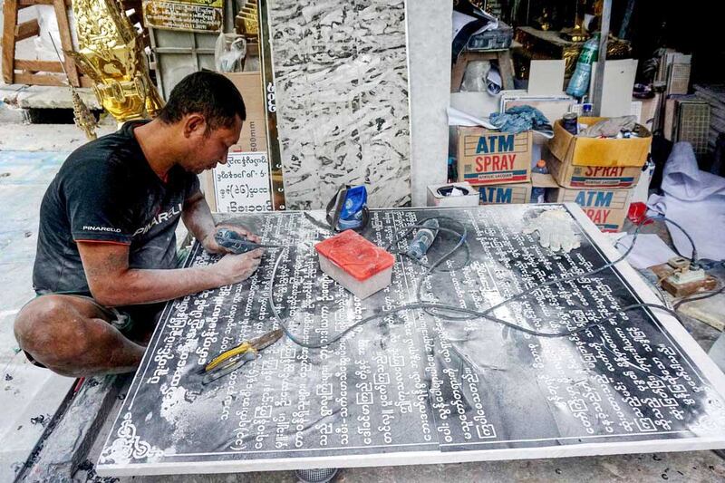 A craftsman inscribes names, donations and wishes on a marble slab for a pagoda. Inscriptions used to take a week but now can be done in a day using digitized fonts on a computer. (Myo Min Soe/RFA)