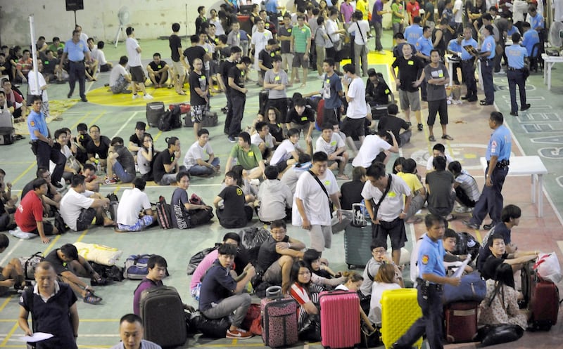 Hundreds of Taiwanese and mainland Chinese people rounded up by Philippine police on suspicion of being involved in a major telephone scam wait to be processed by authorities at a police stadium in the town of Canlubang, Laguna province, south of Manila, Aug. 23, 2012. Credit: AFP