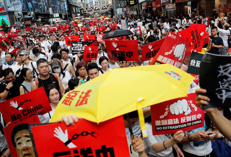 Demonstrators hold yellow umbrellas, the symbol of the Occupy Central movement, and placards during a protest against the proposed extradition bill in Hong Kong, June 9, 2019. (Tyrone Siu/Reuters)