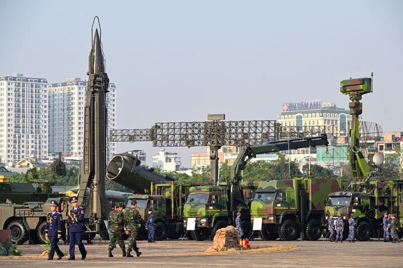 Vietnam's military officials walks near (L-R) a Russian R-17E (Scud-B) surface-to-surface missile, a 4K44b Redut coastal missile complex and a radar during the Vietnam 2024 International Defense Expo in Hanoi on Dec. 19, 2024.