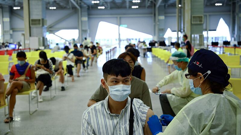 2021 年 8 月 23 日，在台湾，一名医务人员在台北疫苗接种点注射高端疫苗。（路透社）