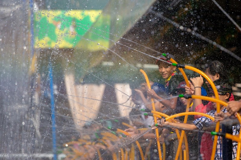 A photo of the Thingyan celebration in Yangon in 2019 shows children spraying water at revelers. Credit: AFP