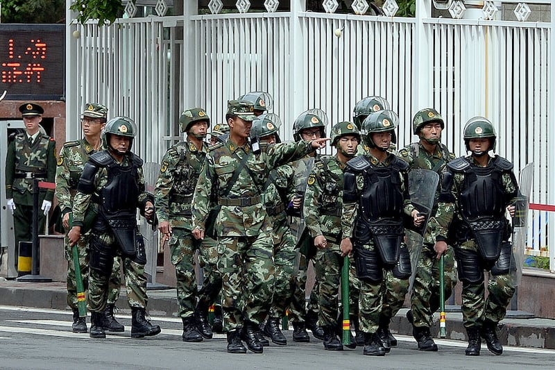 Armed Chinese paramilitary police patrol a street in Urumqi, the capital of China's Xinjiang province, May 23, 2014.