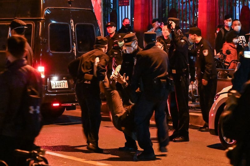 A man is arrested while people gathering on a street in Shanghai on November 27, 2022, where protests against China's zero-Covid policy took place the night before following a deadly fire in Urumqi, the capital of the Xinjiang region. Credit: AFP